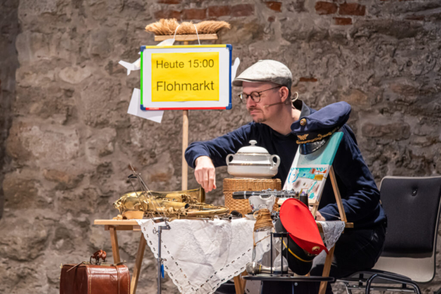Flohmarktrequisiten und Schauspieler auf der Bühne