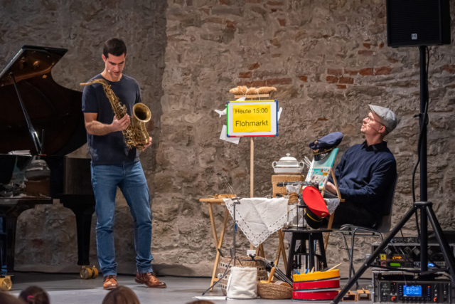 Markus Osztovics mit Saxophon auf der Bühne mit Philipp Eder